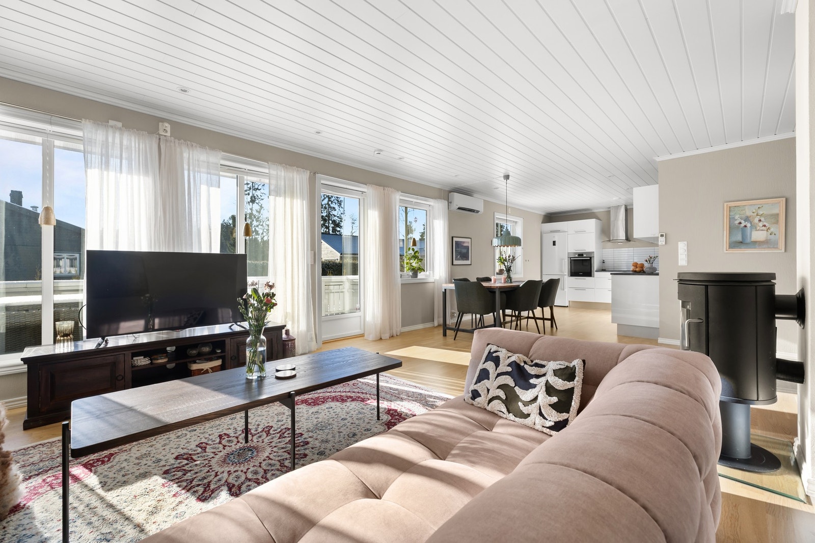 Åpen stue/kjøkken-løsning i lyse, moderne farger. Galleribilde