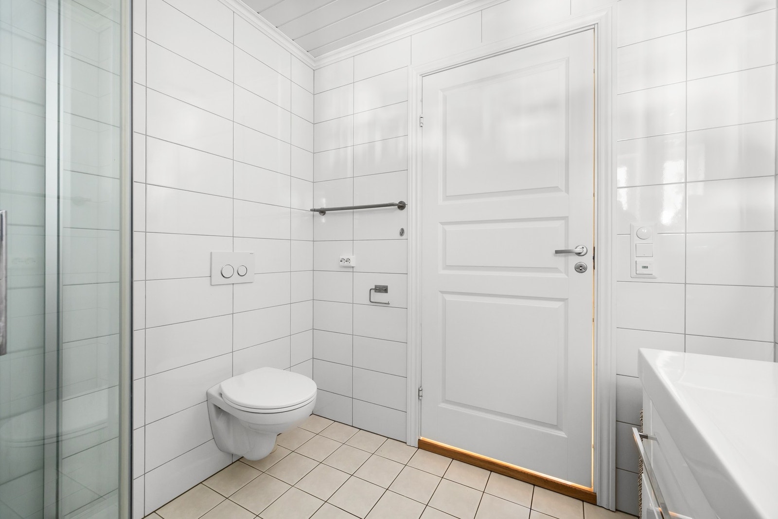 Badet har servantinnredning med skuffer og speil, vegghengt toalett og dusjkabinett. Galleribilde