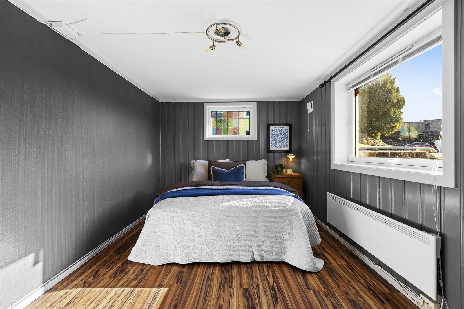 Romslig soverom med plass til dobbeltseng, nattbord og annet soveromsmøblement Galleribilde