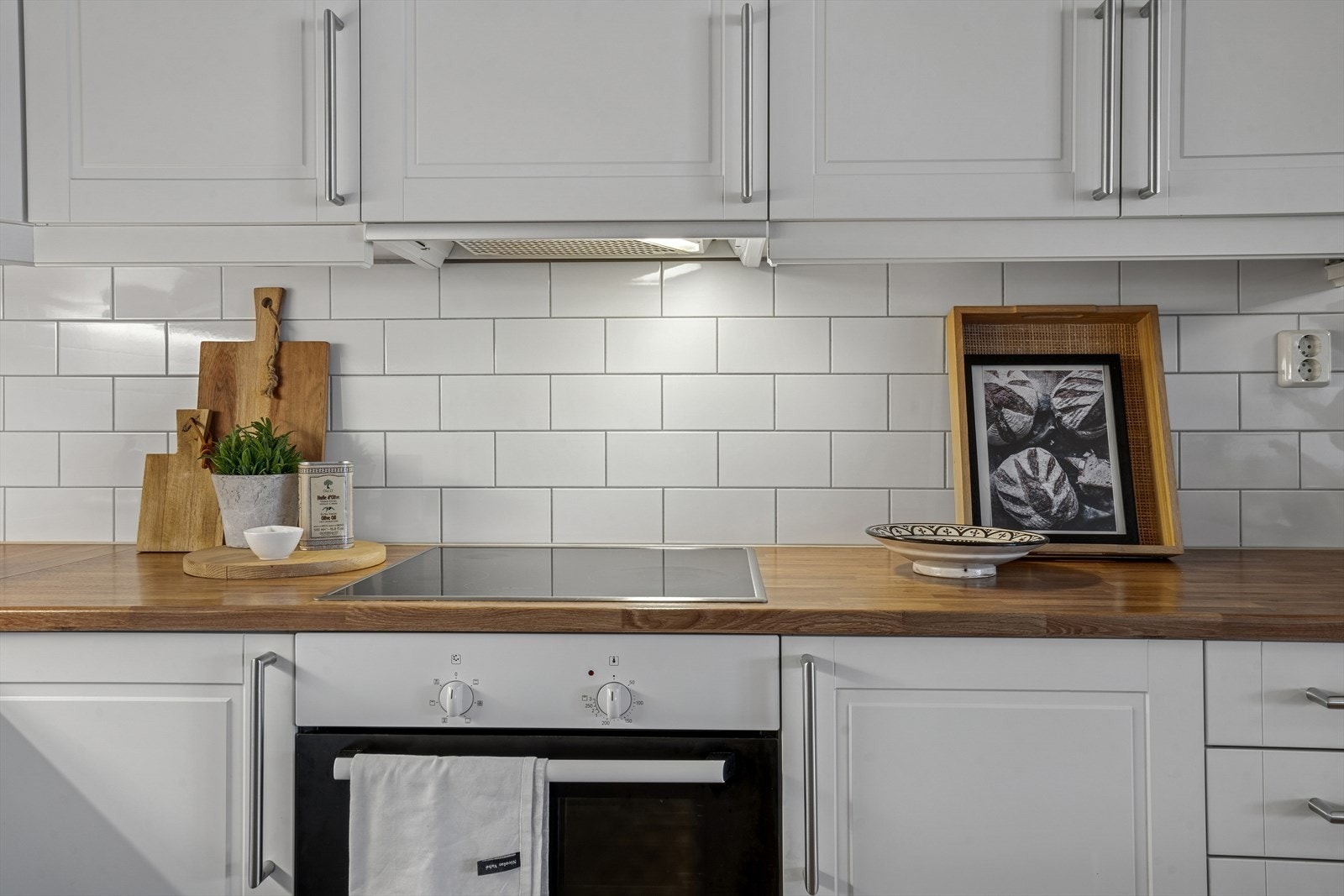 Det er montert fliser og belysning mellom over- og underskapene, praktisk ved matlaging. Galleribilde