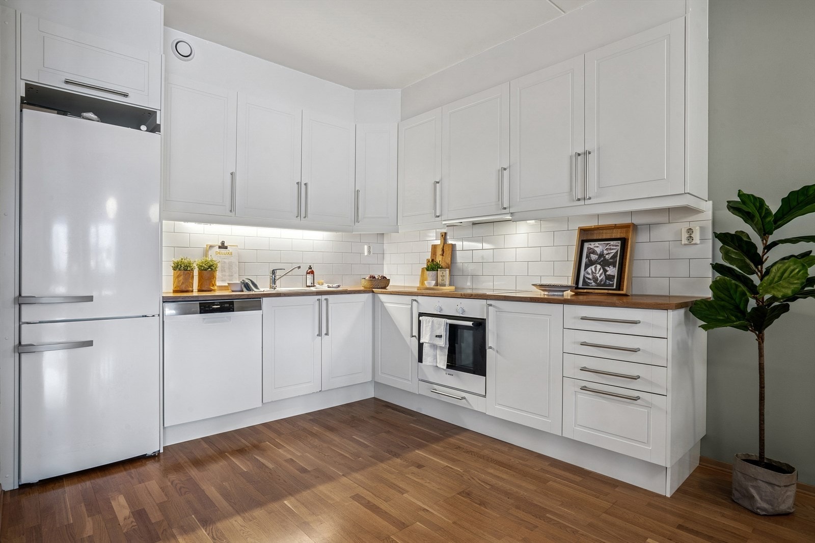 Kjøkkeninnredningen har hvit, profilert fronter og laminert benkeplate med oppvaskkum. Galleribilde