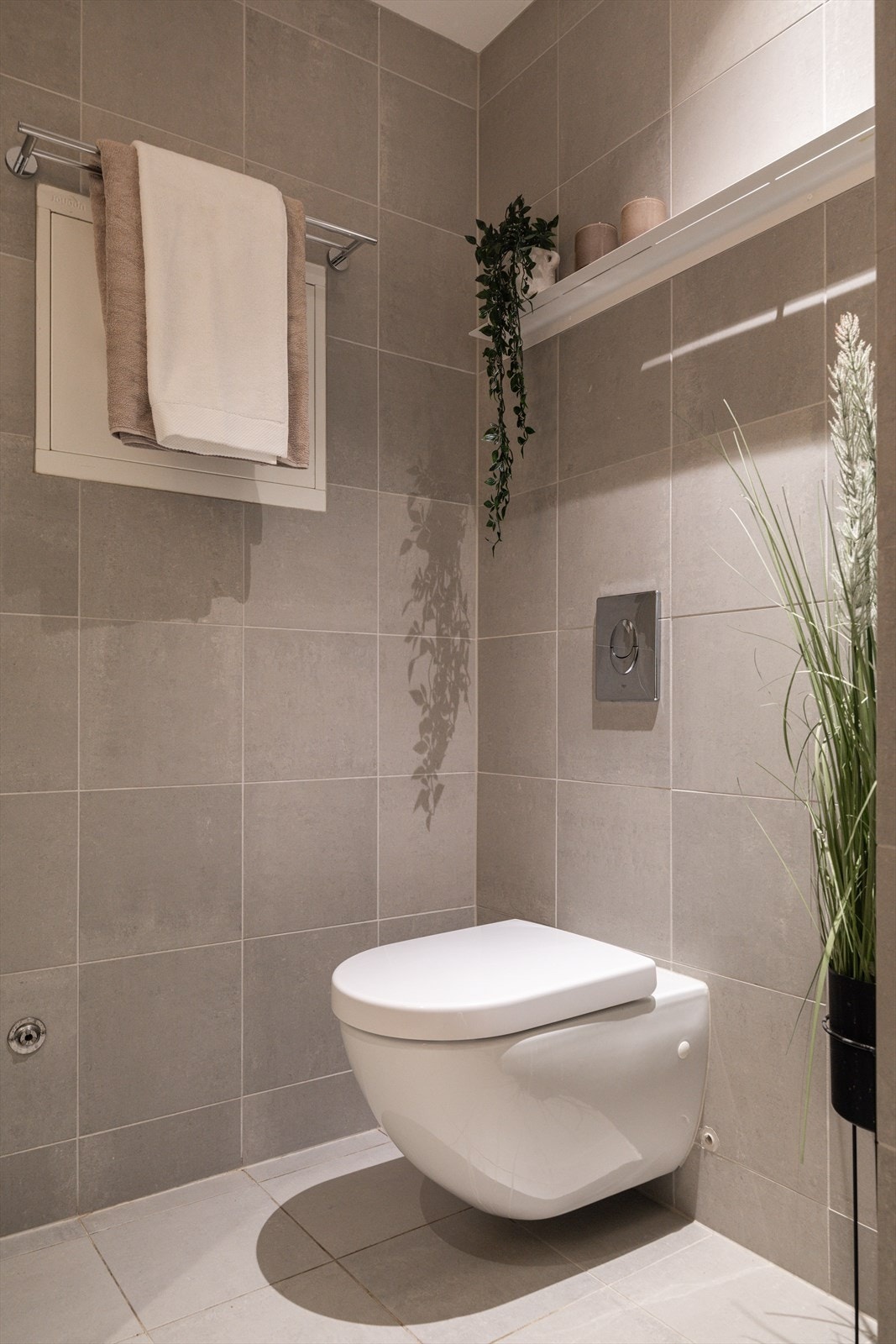 Vegghengt toalett, praktisk håndkleholder og smart hylleløsning som gir ekstra oppbevaringsplass Galleribilde