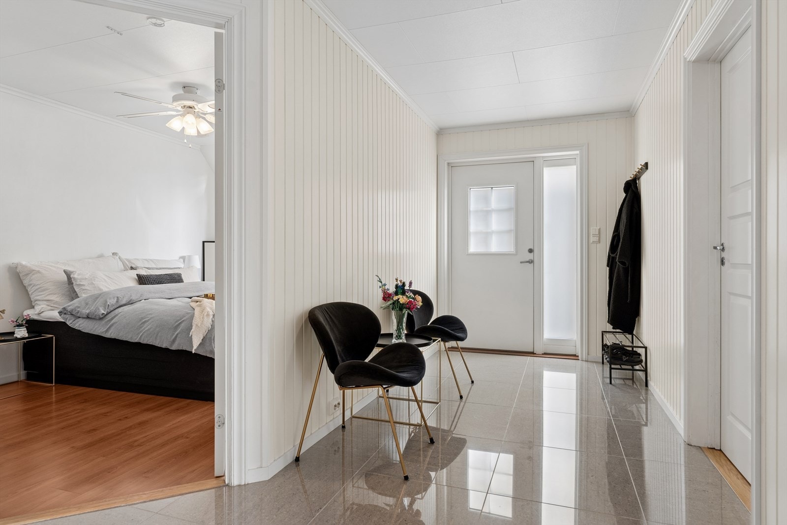 Entréen ønsker deg velkommen inn i boligen med et lyst og innbydende preg. Gulvet er flislagt, noe som er praktisk og slitesterkt i en inngangssone. Her er det god plass til å henge fra seg yttertøy og sette fra seg sko Galleribilde