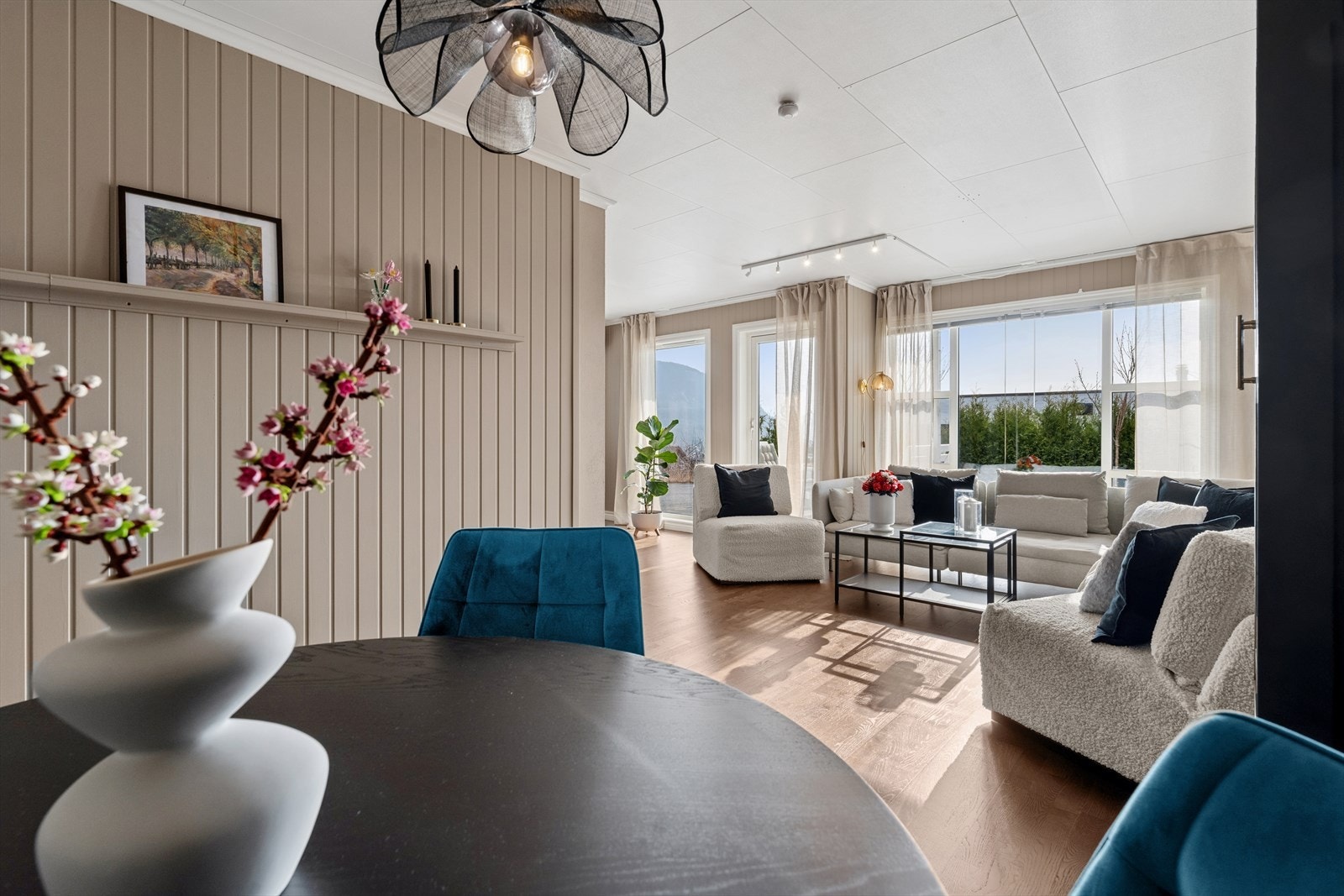 Store vindusflater slipper inn rikelig med naturlig lys, noe som sammen med de duse veggtonene bidrar til en lys, luftig og behagelig atmosfære i rommet Galleribilde