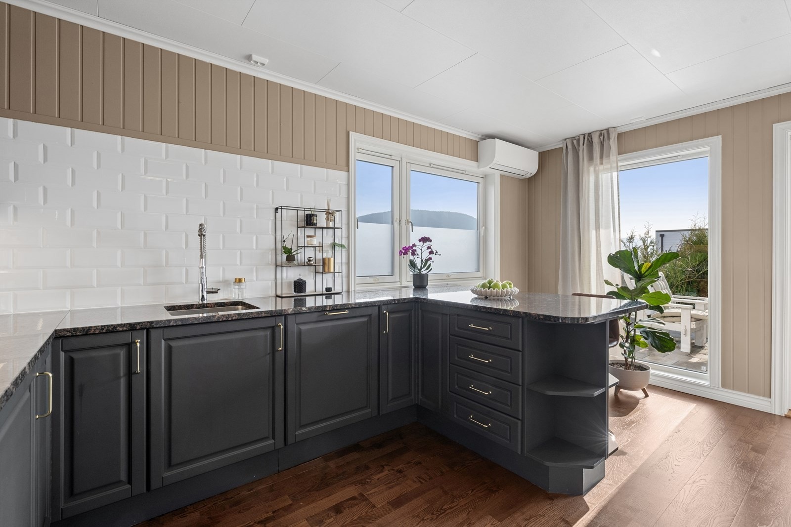 Av hvitevarer er kjøkkenet utstyrt med komfyr, induksjonstopp, oppvaskmaskin og kjøl-/fryseskap Galleribilde