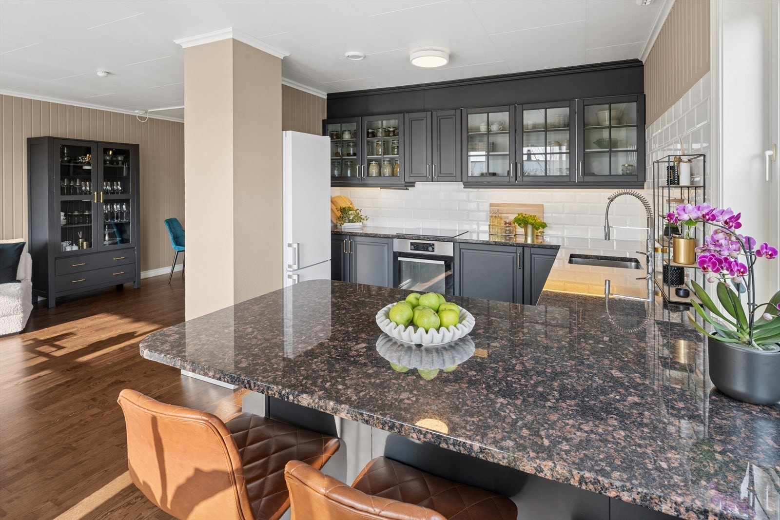 Kjøkkenet ligger i åpen løsning mot stuen og oppleves som både praktisk og sosialt. Kjøkkenet har god benkeplass med benkeplate i stein og nedfelt vask, mellom benkeplaten og overskapene er det fliser på veggene Galleribilde