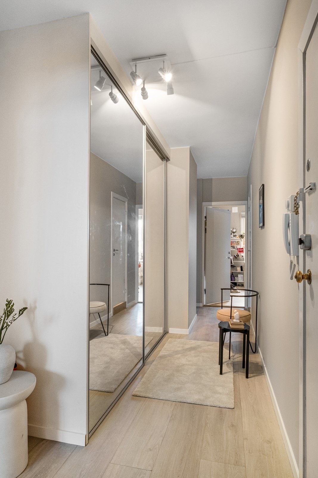 Velkommen inn! Innbydende entré med god plass til sko og yttertøy i stor skyvedørsgarderobe med speildører. Galleribilde