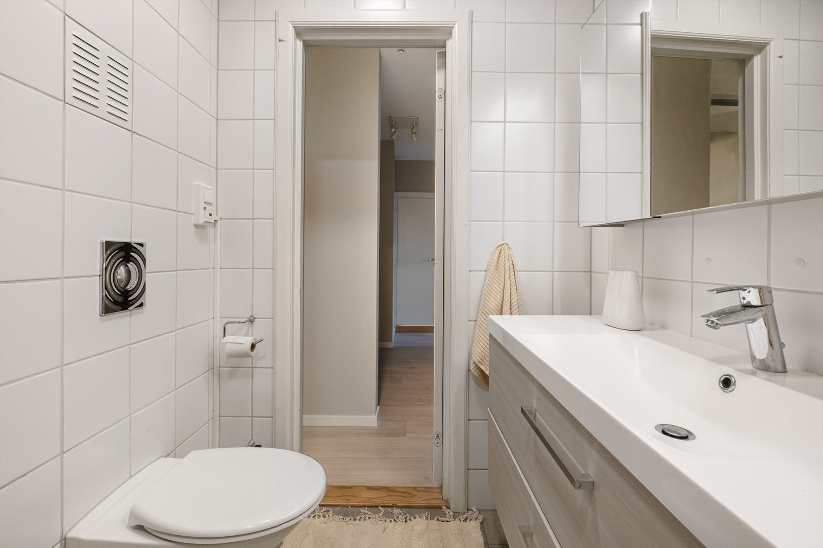 Badet er innredet med dusjkabinett, baderomsinnredning med nedfelt servant, speil med belysning, vegghengt toalett samt opplegg for vaskemaskin og tørketrommel. Galleribilde