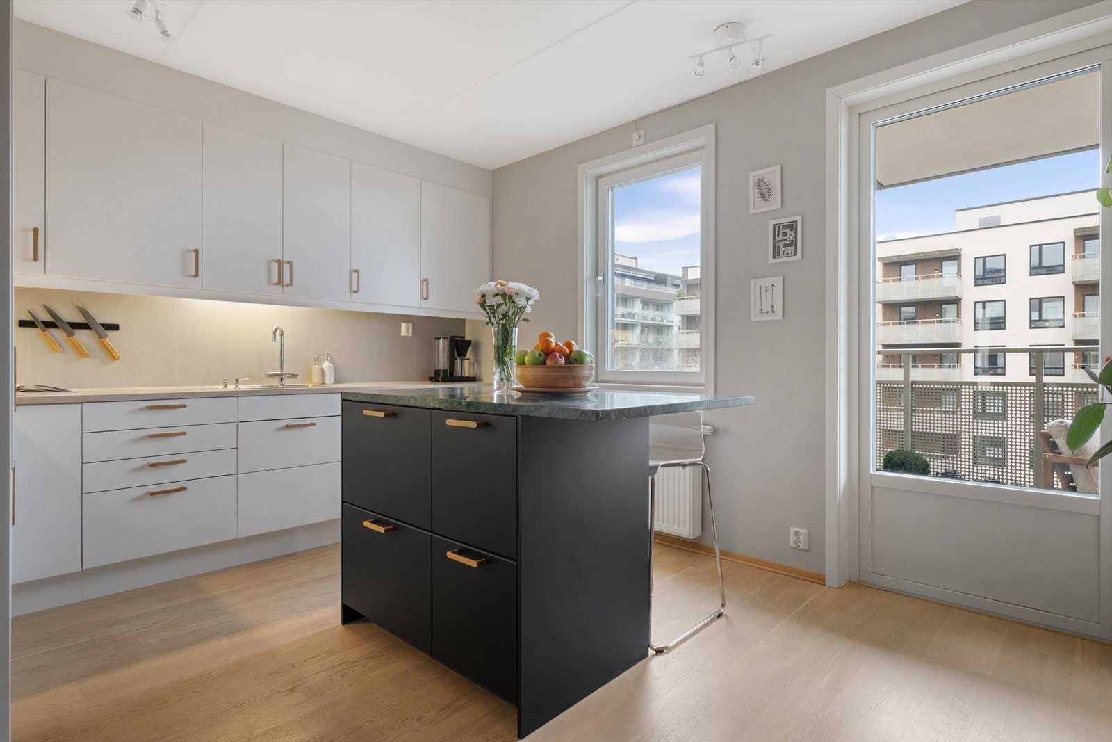 Kjøkkenet har en frittstående kjøkkenøy med benkeplate i stein som gir både ekstra arbeidsplass og en sosial sone i rommet Galleribilde