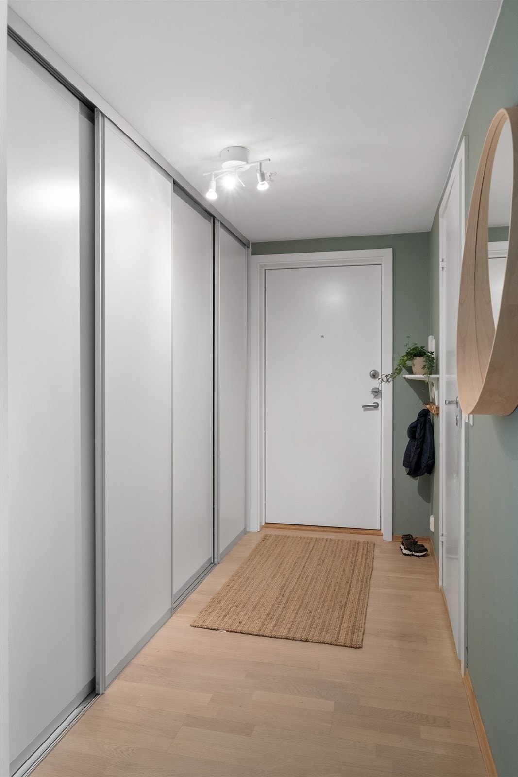 Romslig entré med god plass til oppheng av yttertøy og oppbevaring av sko i skyvedørsgarderobe Galleribilde