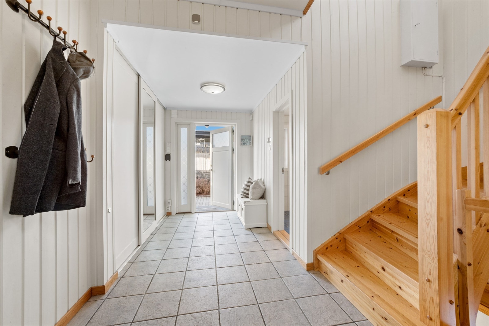 Man kommer inn i en romslig entré med flislagt gulv og varmekabler. Galleribilde