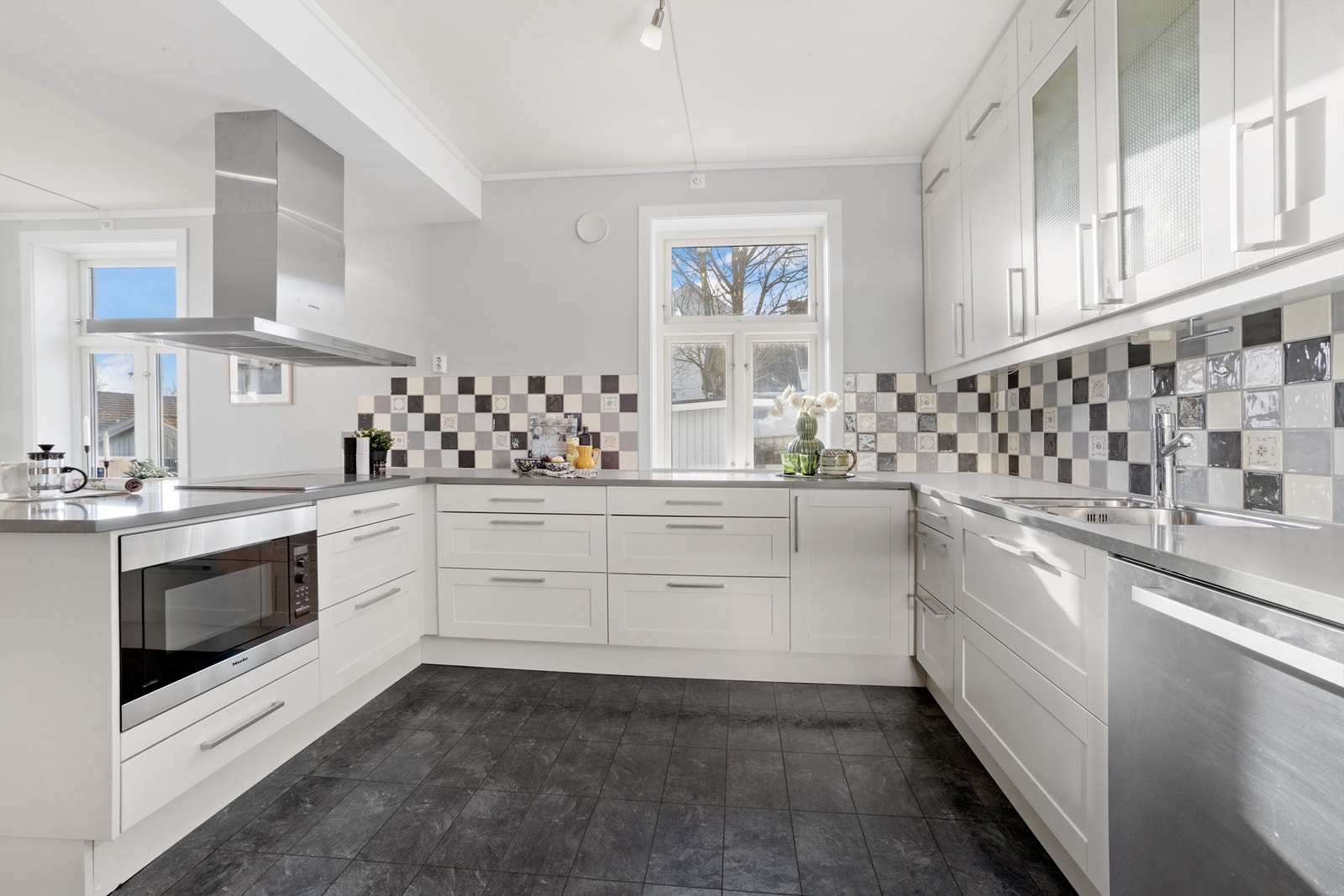 Innredningen har profilerte fronter, kompositt benkeplate og en fritthengende ventilator fra Siemens (2020). Galleribilde