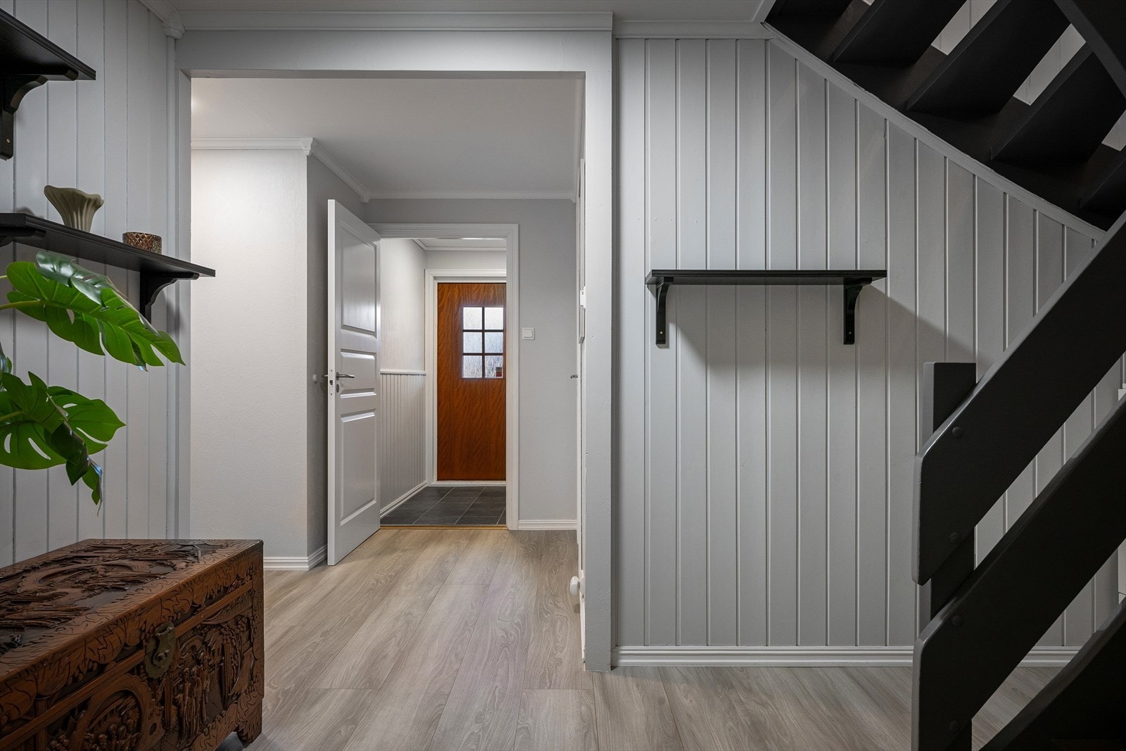En liten og praktisk entré leder inn til en romslig gang med god plass til å henge fra seg yttertøy. Galleribilde