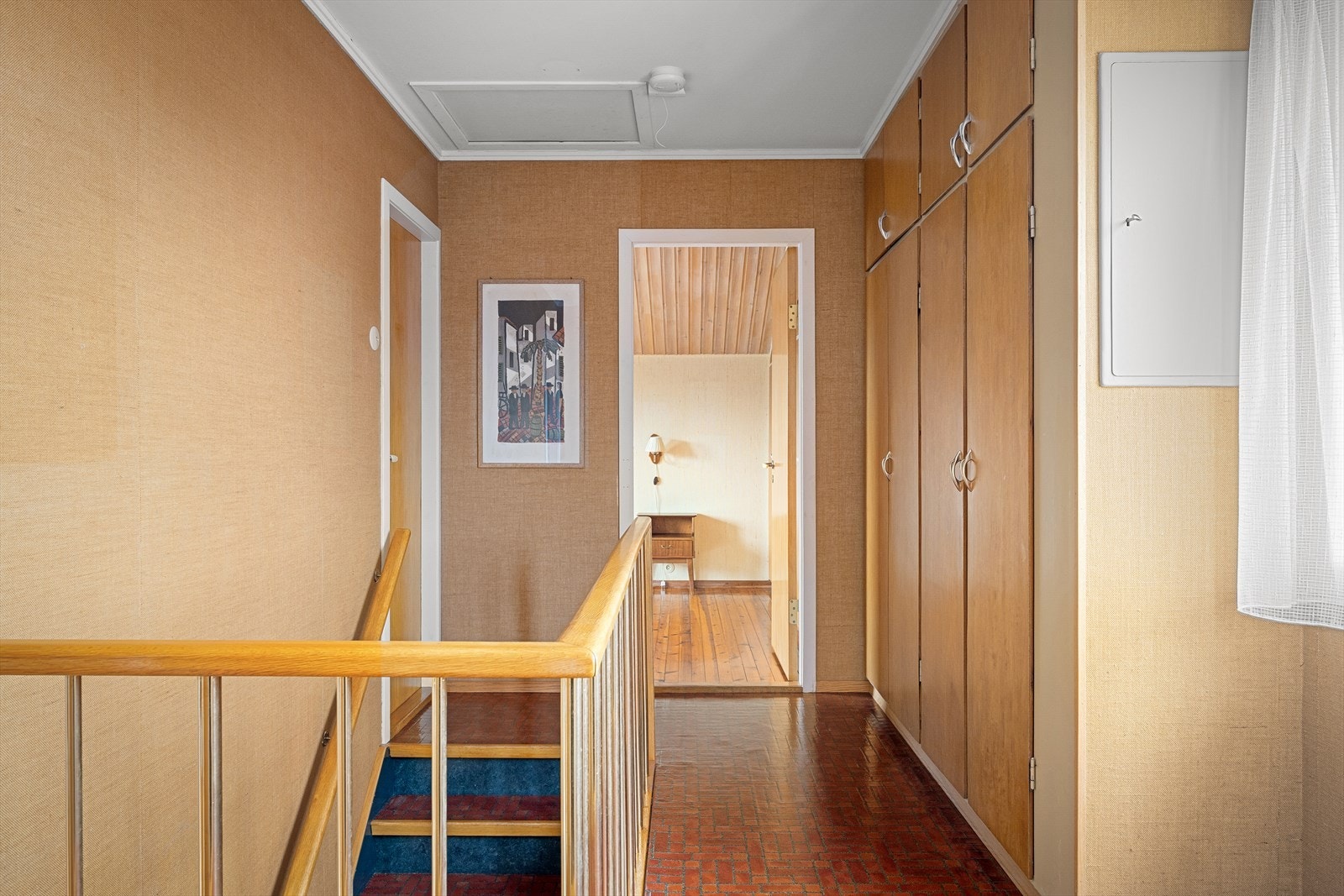 Arkitektonisk og detaljrik gang med rekkverk og stedbyggede skap. Galleribilde