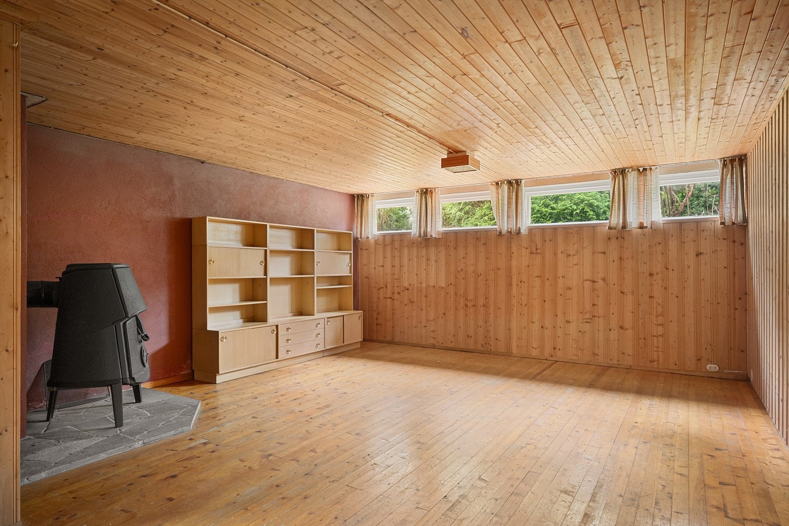 En meget romslig kjellerstue med vedfyrt ovn. Rikelig med plass til flere soner for både gaming, tv, spill og sosial samling. Galleribilde