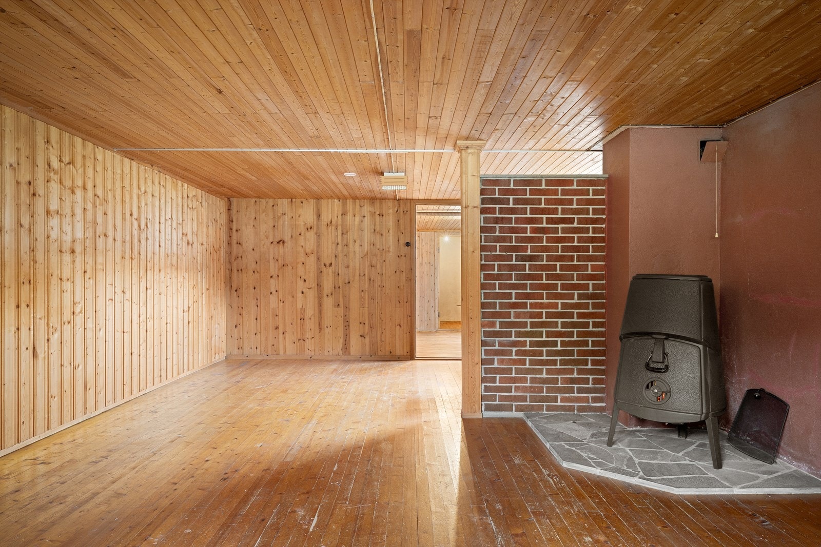 En meget romslig kjellerstue med vedfyrt ovn. Rikelig med plass til flere soner for både gaming, tv, spill og sosial samling. Galleribilde