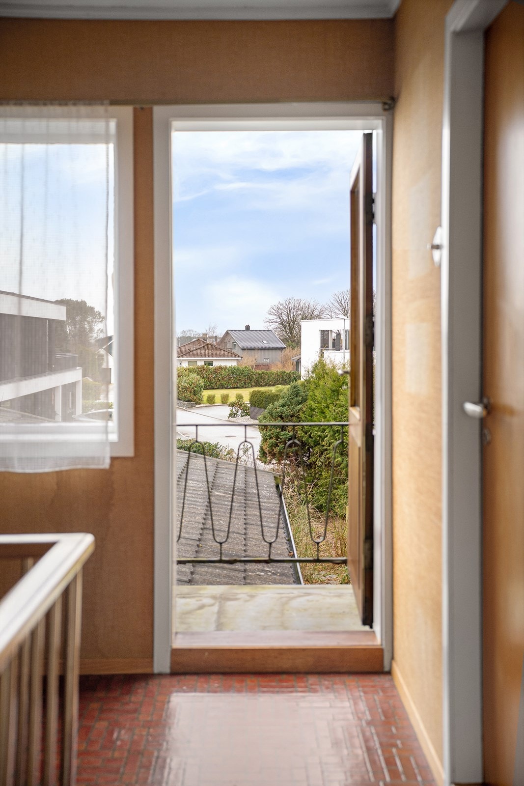 Fra gang og ut på balkong med stålrekkverk. Flotte arkitektoniske detaljer. Galleribilde