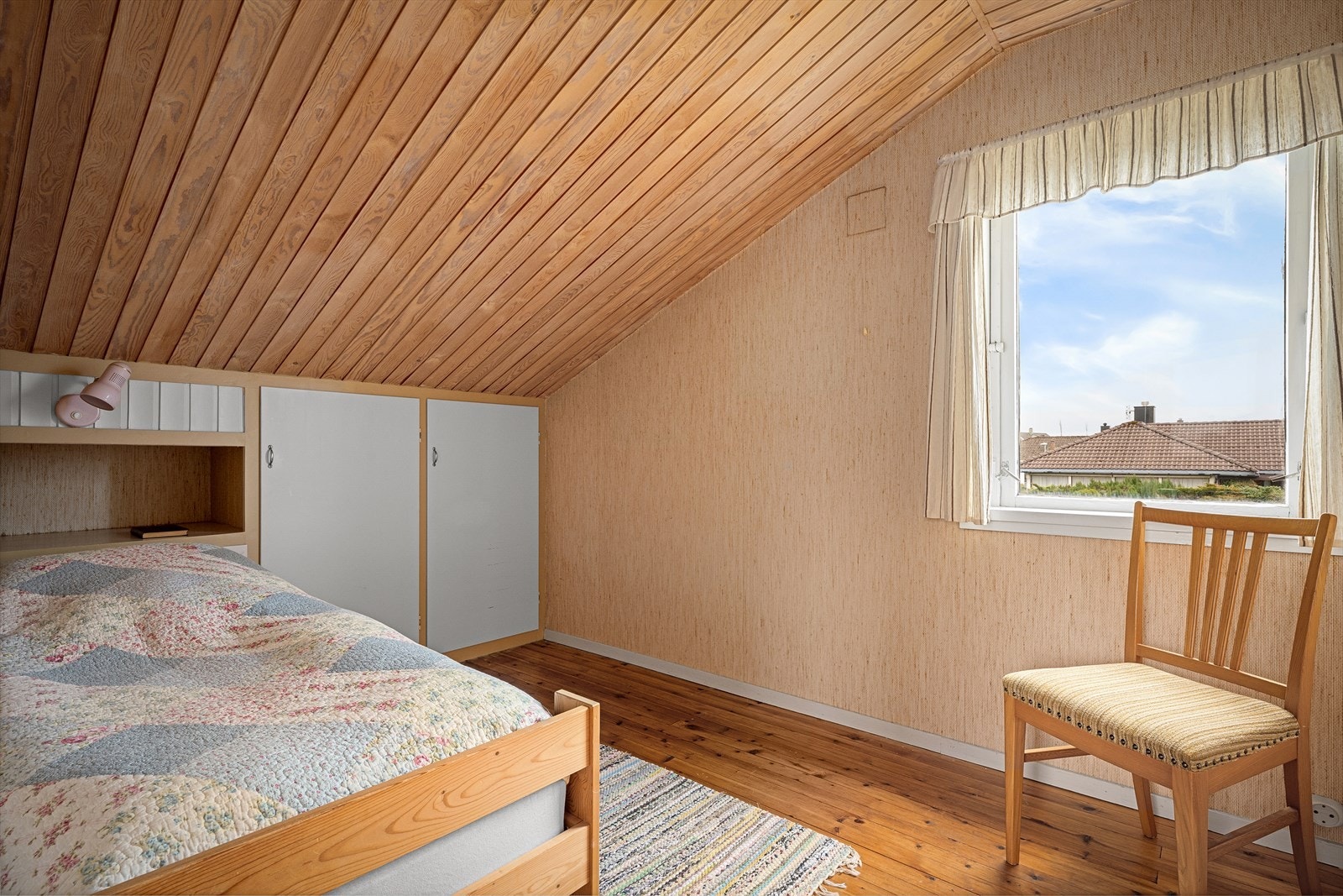 Stedbyggede skap i knevegger med integrert bok og telefonhylle bak seng. Galleribilde