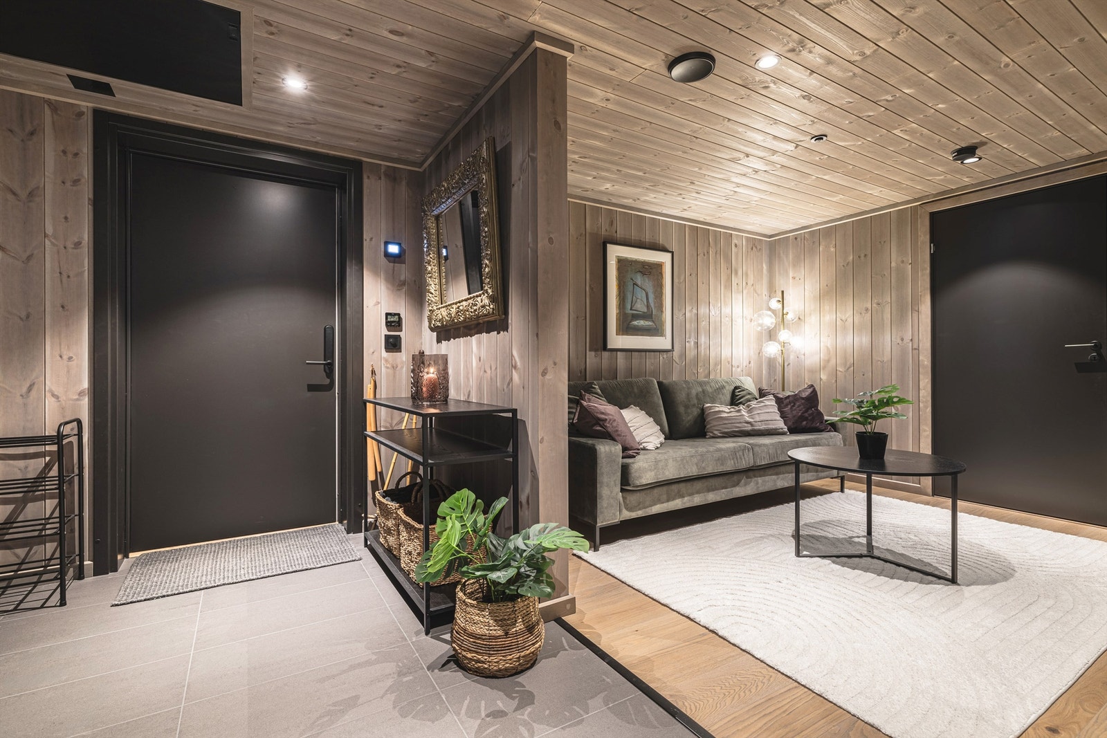 Fra gangen åpner leiligheten seg opp, med en praktisk TV-krok som gir en ekstra sone for avslapning. Galleribilde