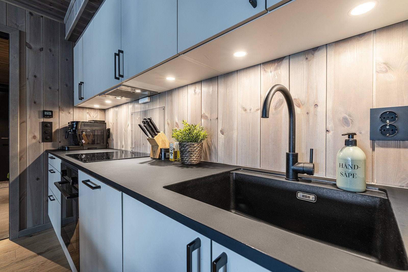 Kjøkkeninnredning fra Sigdal (2024) med glatte fronter, laminert benkeplate og integrerte hvitevarer. Galleribilde