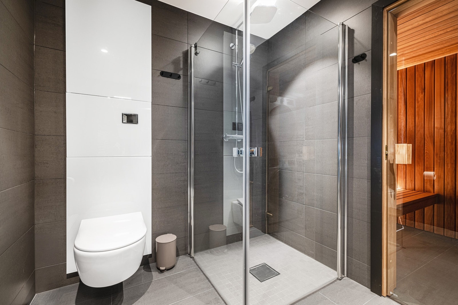 Badet er utstyrt med en romslig dusjnisje og vegghengt toalett med innebygget sisterne fra Tece. Galleribilde