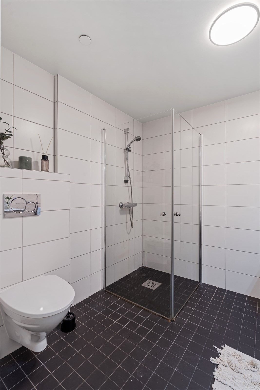 Badet er utstyrt med et praktisk dusjhjørne med innfellbare dører og vegghengt toalett. Galleribilde