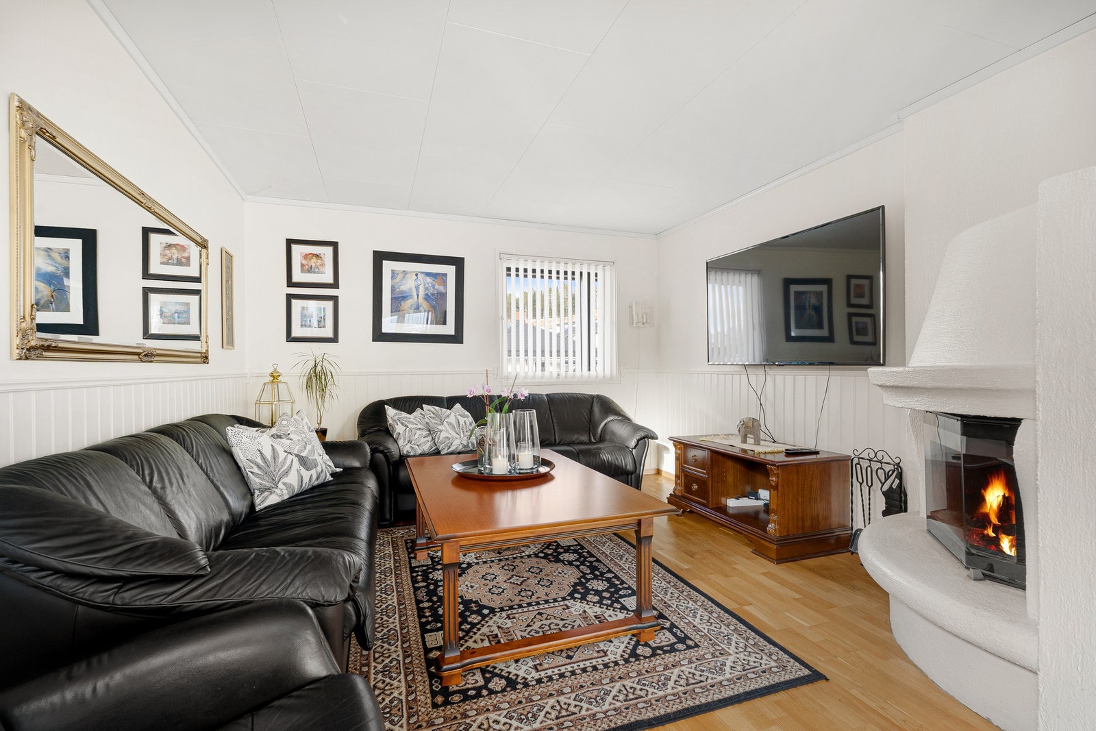 Romslig sofahjørne med en svært trivelig peisovn Galleribilde