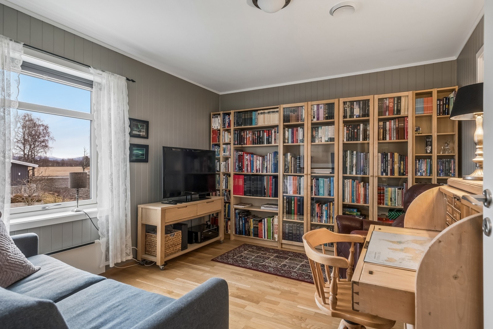Soverom/tv-stue/bibliotek med eget walk in closet med plassbygd innredning Galleribilde
