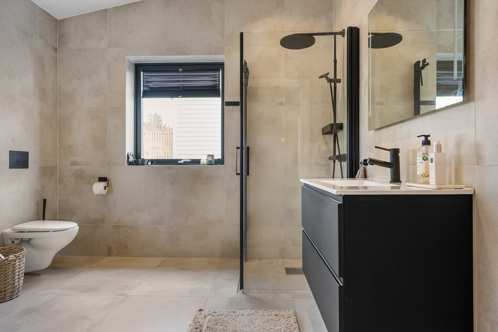 Romslig bad med innredning bestående av dusjnisje, servant med underskap og wc. Galleribilde