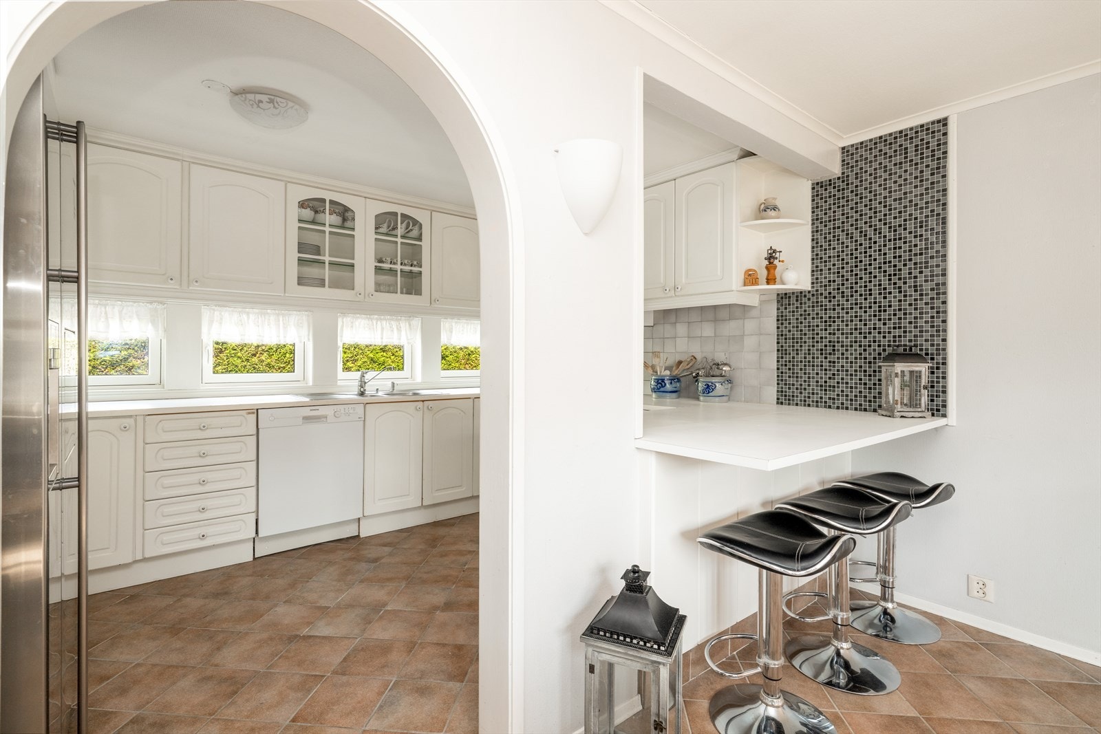 Kjøkken har åpen løsning ut mot spiseplassen, med tre koselig frokostplasser på den ene siden. Galleribilde