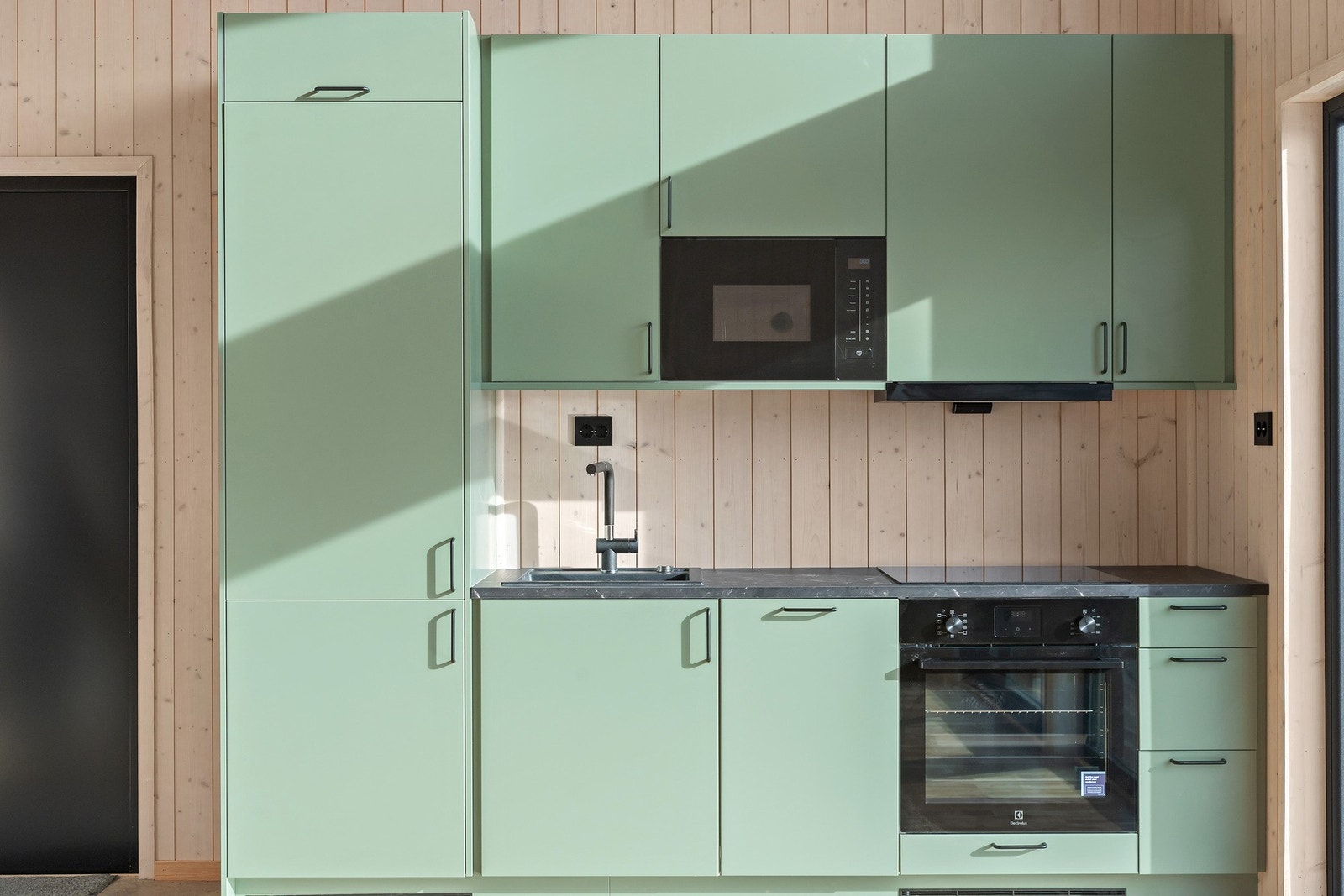 Delikat og komapt kjøkken med fronter i moderne grønnfarge. Galleribilde