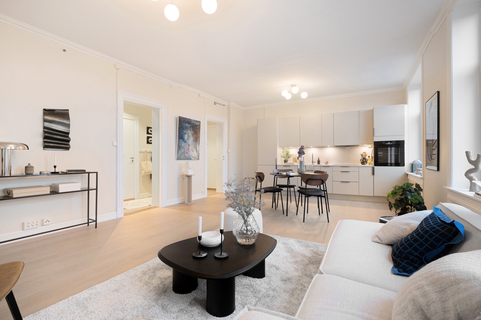 Den åpne løsningen mot kjøkkenet skaper et luftig og sosialt rom med gode møbleringsmuligheter - her kan du enkelt innrede både en stor sofagruppe, spisestue og ekstra sitteplasser. Galleribilde