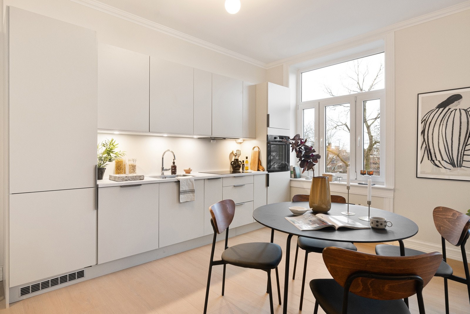 Kjøkkenet har en moderne innredning fra HTH, med glatte fronter og en stilren laminert benkeplate. Galleribilde