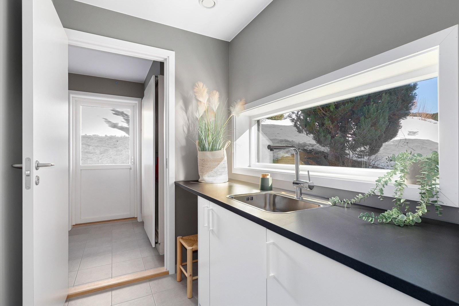 Praktisk vaskerom med egen inngang, utslagsvask og opplegg for vaskemaskin. Galleribilde