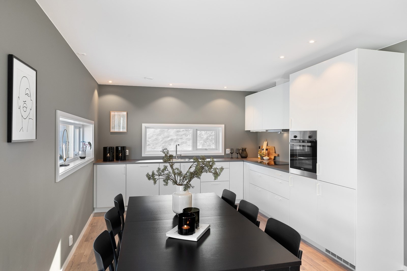 Kjøkkeninnredningen har slette, hvite fronter og integrerte hvitevarer for et rent uttrykk. Galleribilde