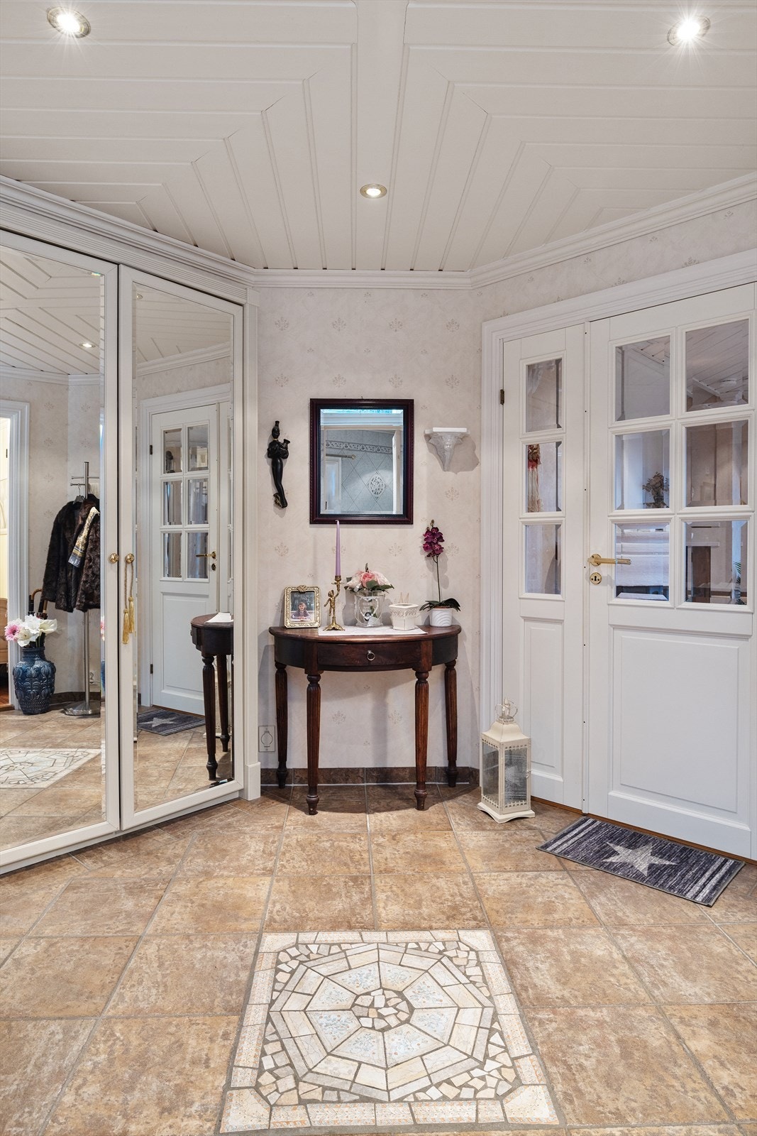 Flislagt, innbydende hall med god plass til oppbevaring av klær og sko i garderobeløsning. Hallen skaper et fint førsteinntrykk av boligen med sine gjennomførte detaljer. Galleribilde