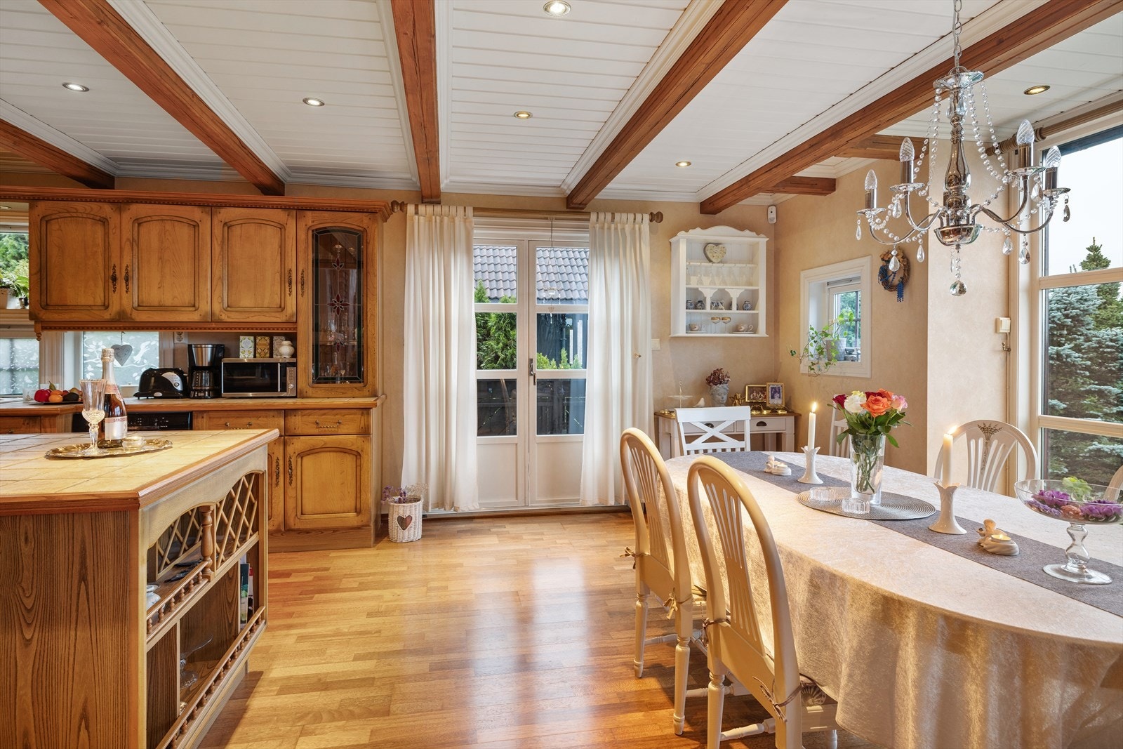 Herskaplig og klassisk kjøkkeninnredning som byr på en praktisk utforming med mye benkeplass, profilerte eikefronter og benkeplate av fliser. Galleribilde