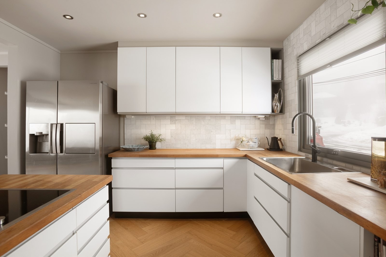 Kjøkkenet har glatter fronter og benkeplate i heltre Galleribilde