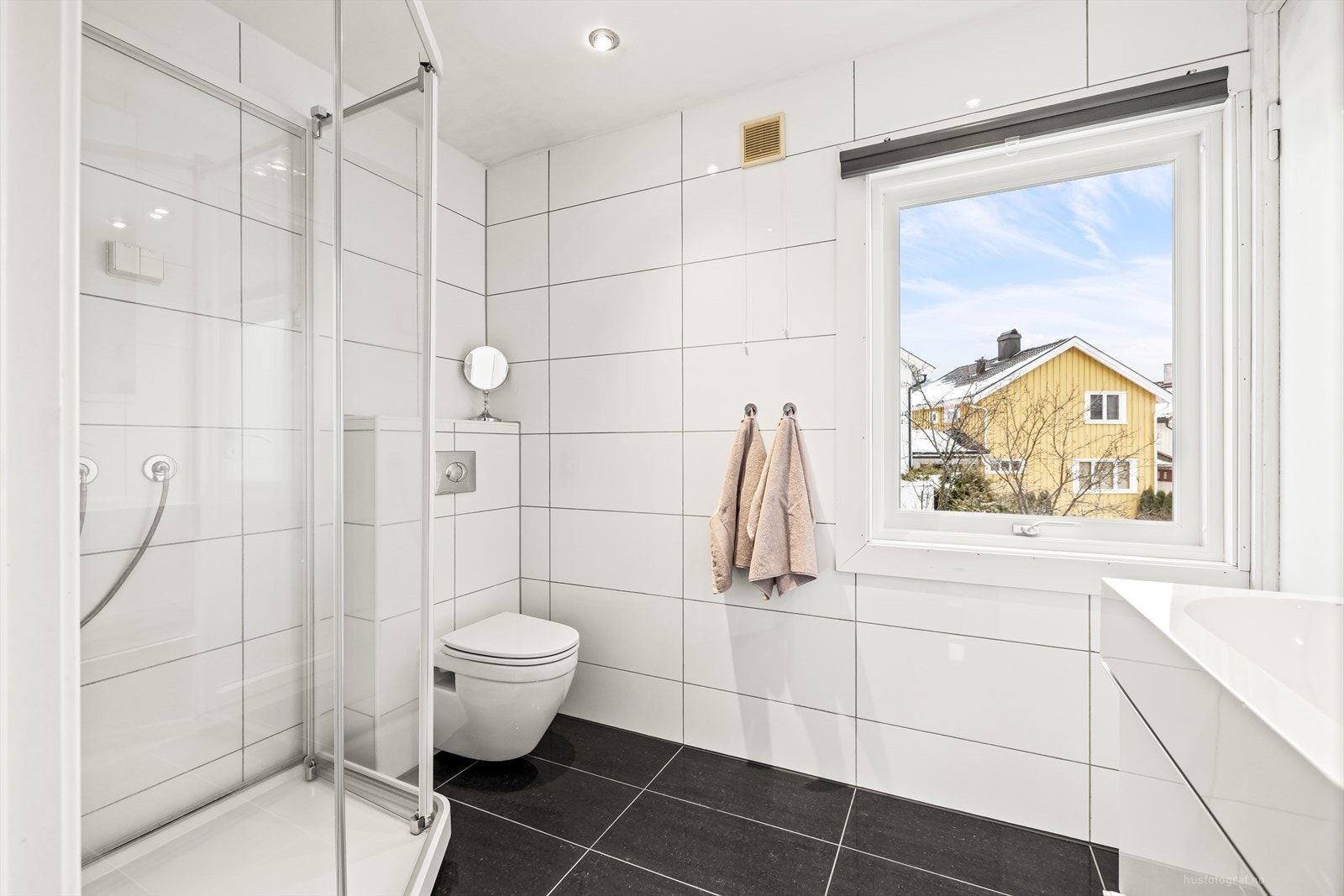 Pent flislagt bad med varmekabler i gulv og downlights i himling Galleribilde