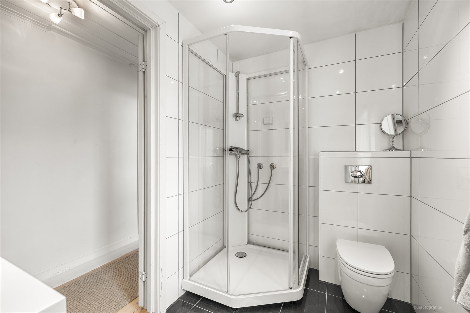 Bad inneholder dusjkabinett, vegghengt klosett, baderomsinnredning med servant og speil Galleribilde