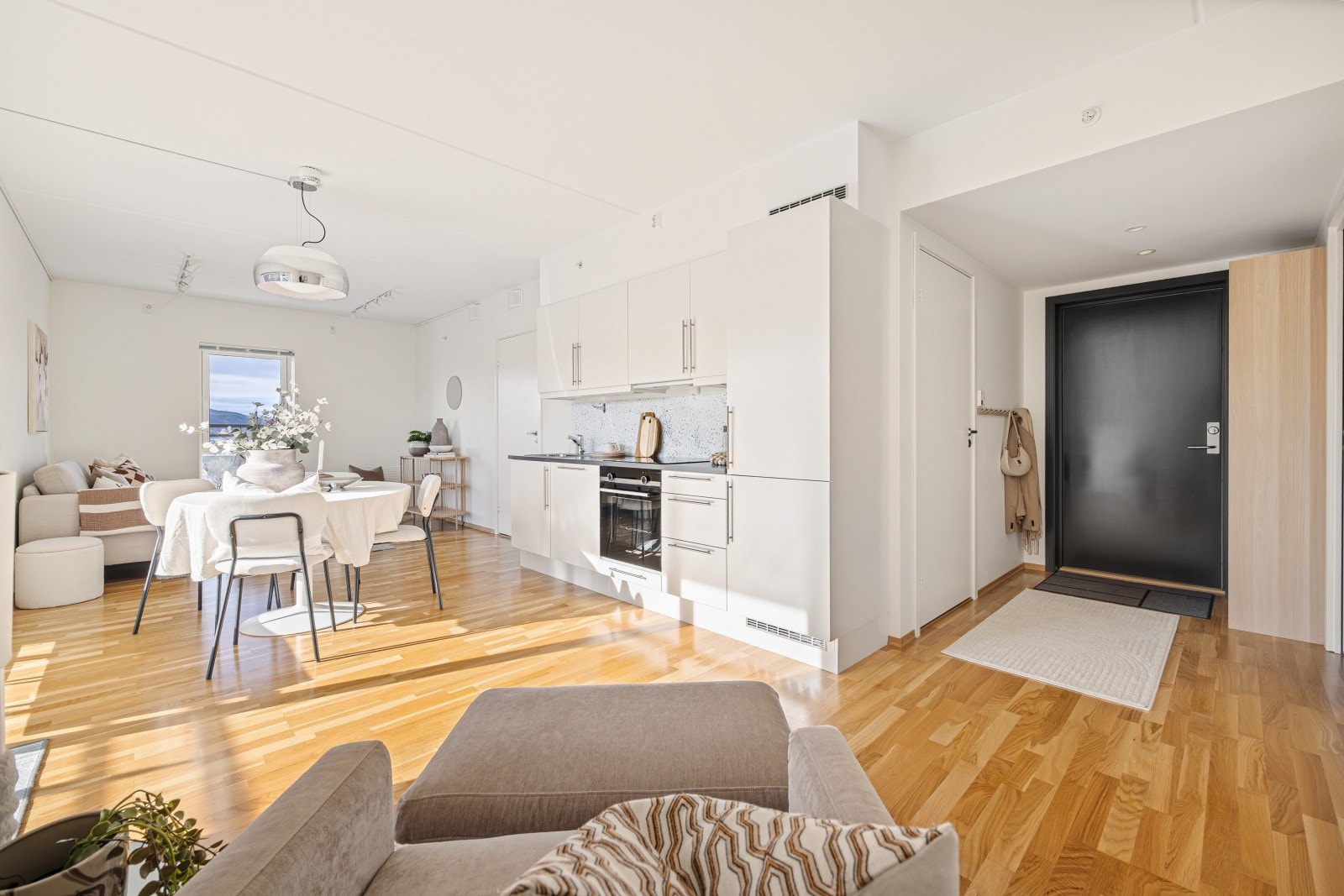 Fra entréen åpner leiligheten seg opp mot det store allrommet. Oppvarming via fjernvarme gir en jevn og behagelig temperatur, året rundt. Galleribilde