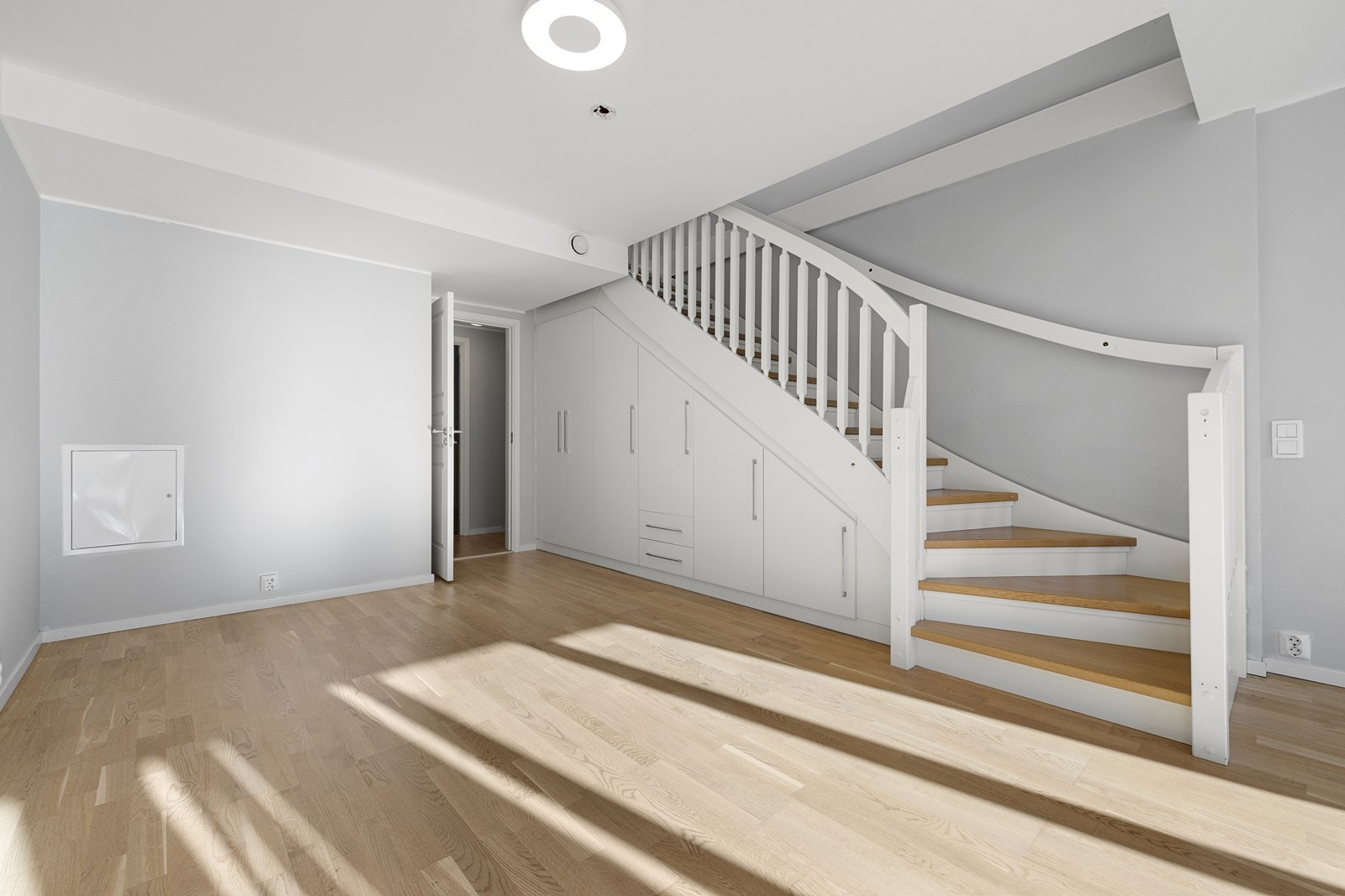 Praktisk skap- og oppbevaringsløsning i underkant av trapp, som også gir en dybde til rommet. Galleribilde