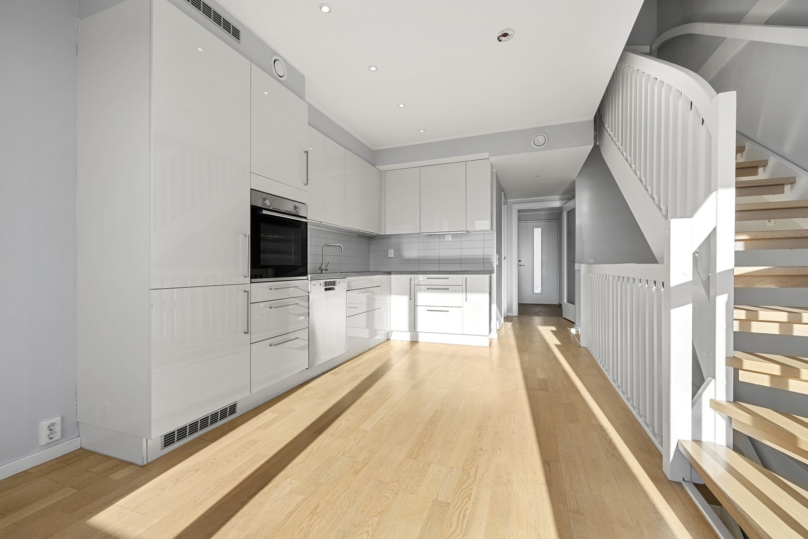 Innredningen består av hvite, slette fronter, laminat benkeplate og flislagt sprutsone. Galleribilde