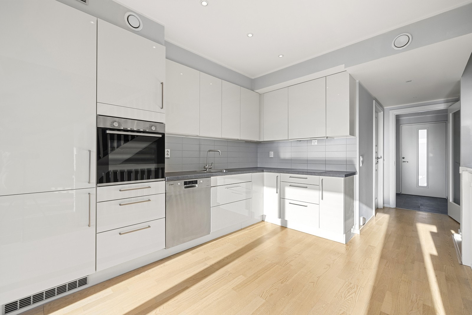 Downlights i tak, parkett på gulv og malte overflater. Tilgang til trapperom. Galleribilde