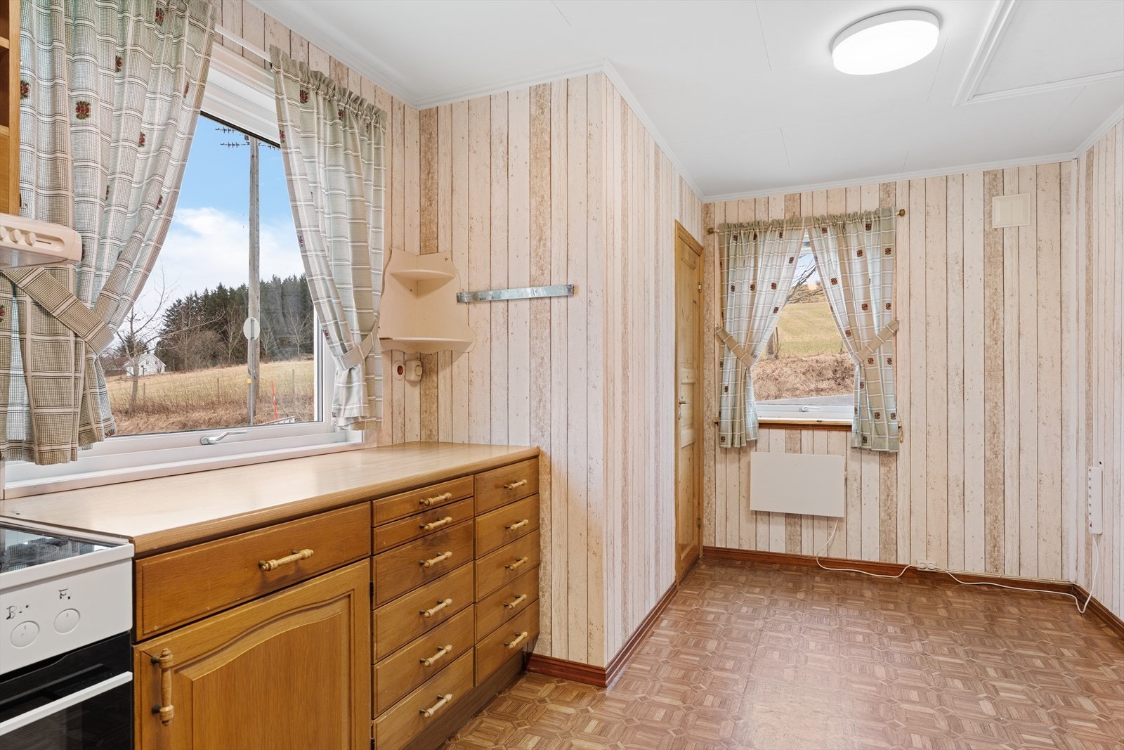 Kjøkkenet har innredningen med profilerte fronter, laminat benkeplate og frittstående hvitevarer Galleribilde