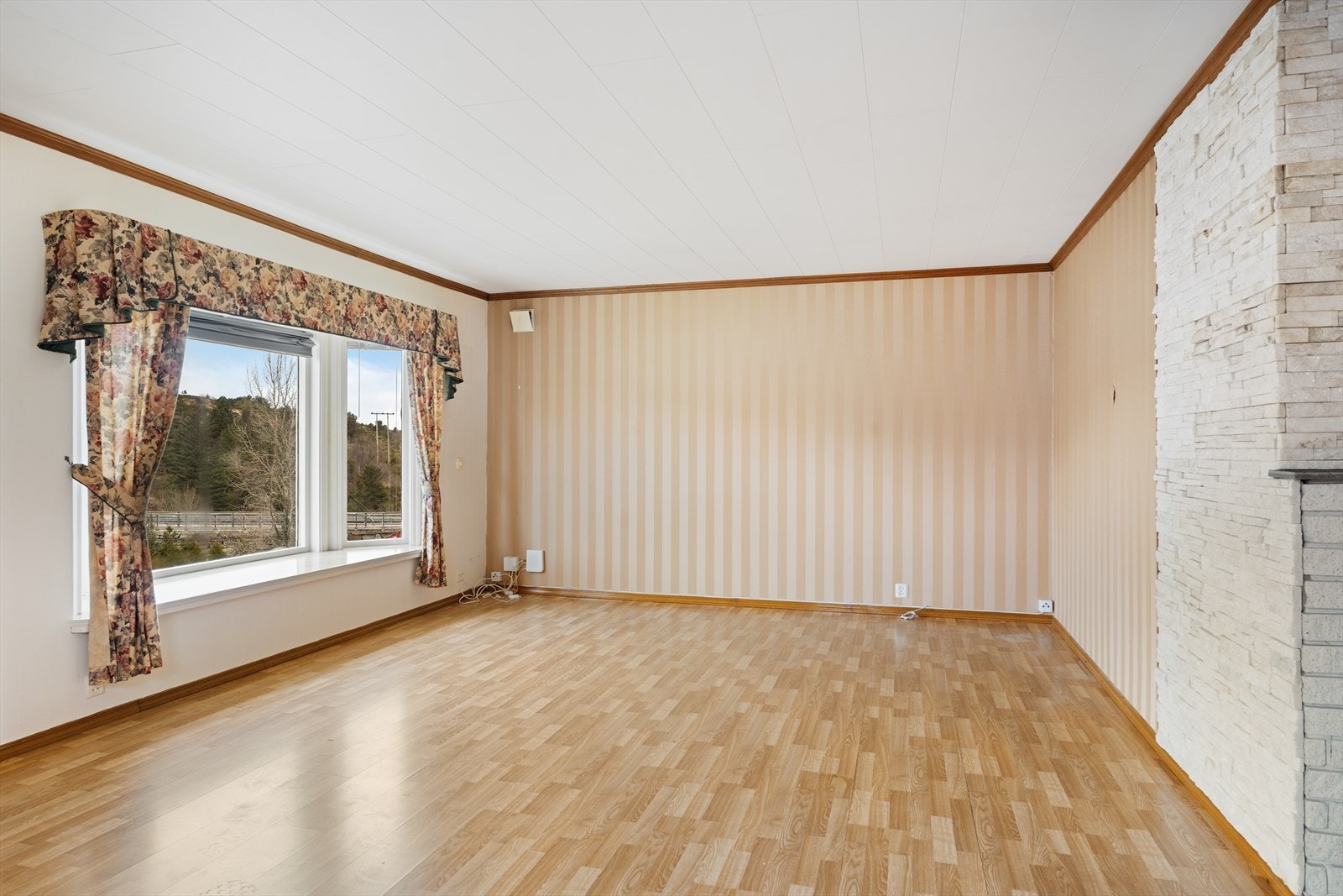 Boligen har en lys og romslig stue med plass til sofagruppe og spisebord Galleribilde