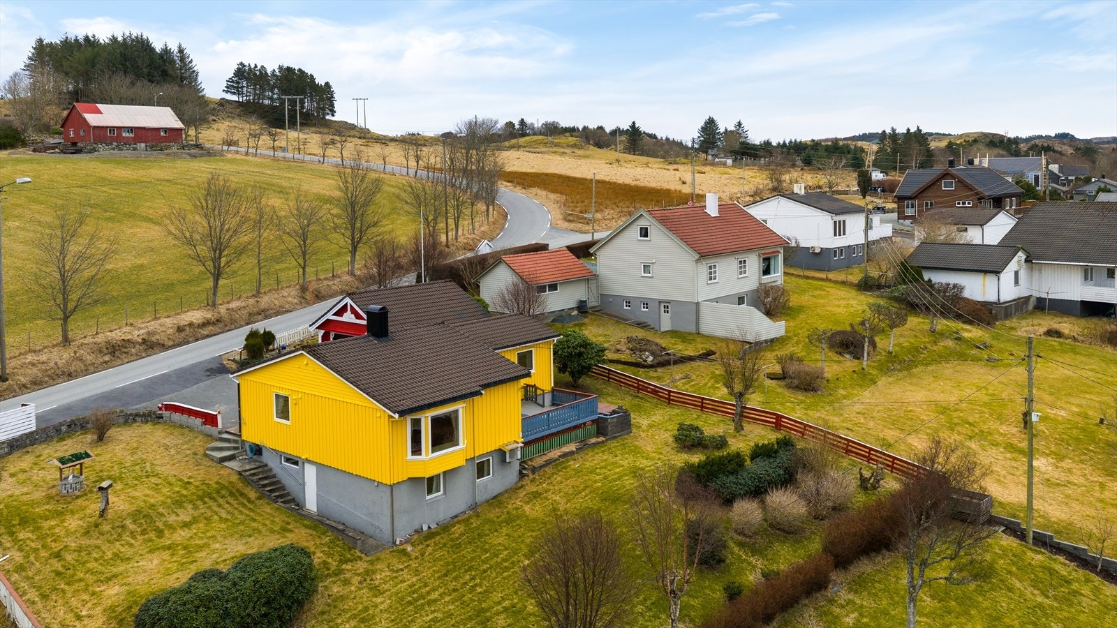 Tomten er på 911,8 kvm og er opparbeidet med asfaltert gårdstun samt hage med plen og noe beplantning i skrånet terreng Galleribilde