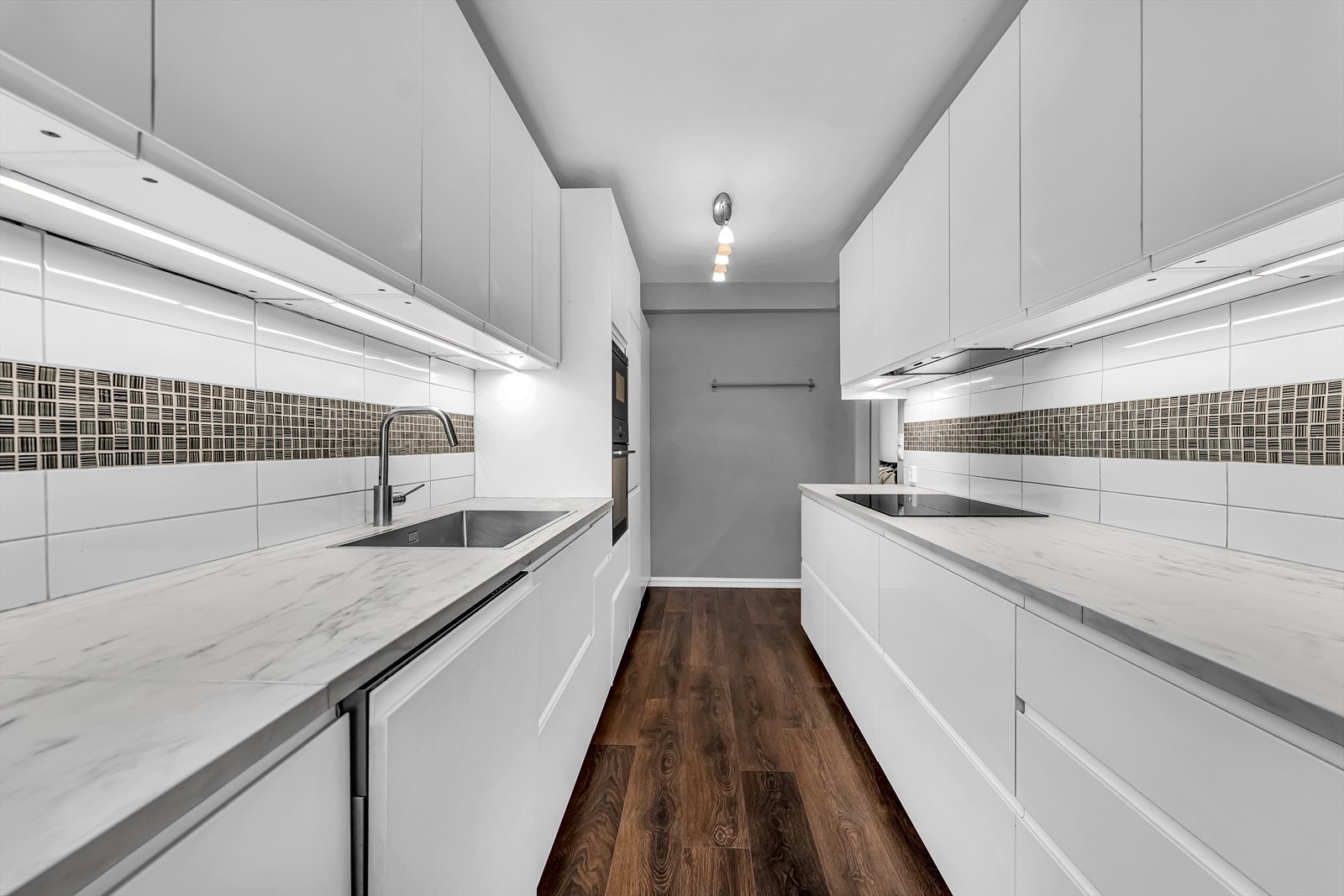 Kjøkkenet er utstyrt med integrerte hvitevarer, som stekeovn, mikrobølgeovn, induksjonsplatetopp, oppvaskmaskin og kjøleskap. Galleribilde