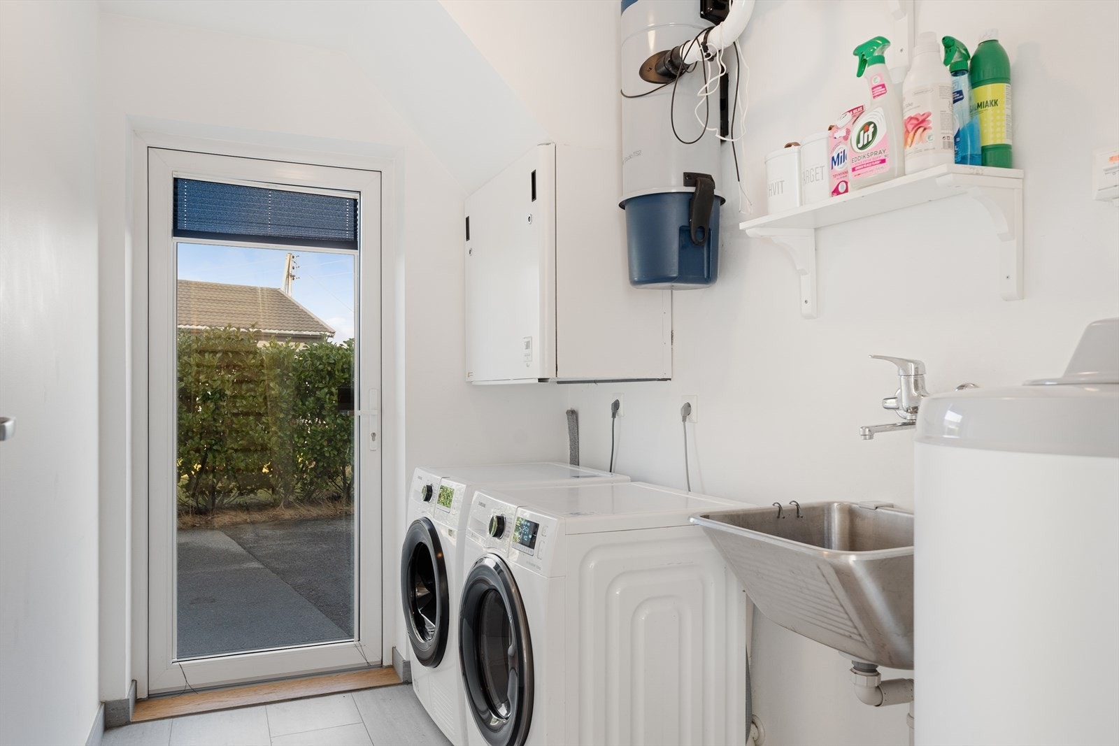 Praktisk vaskerom med egen utgang til uteområdet. Rommet har utslagsvask og opplegg for vaskemaskin. Galleribilde