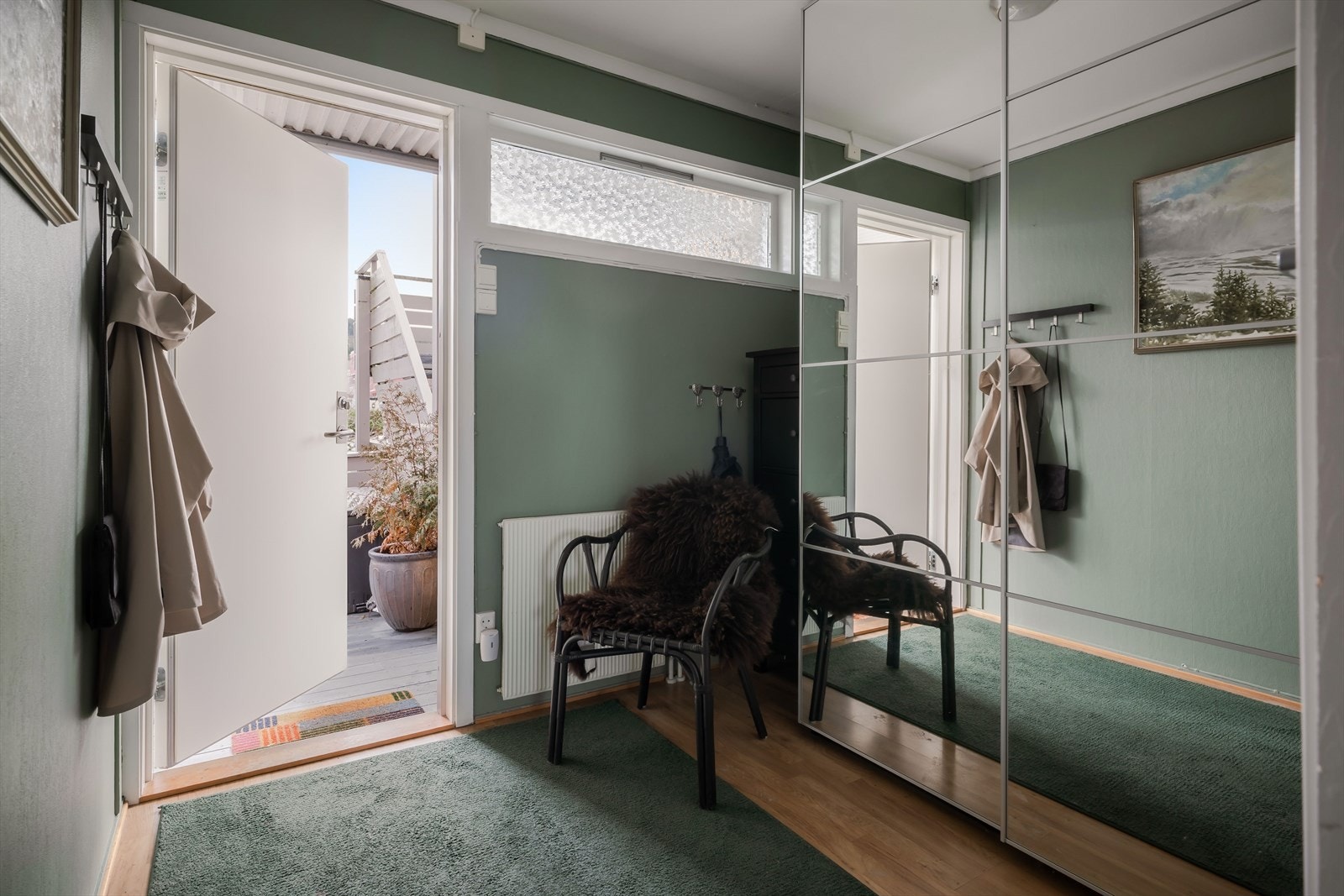 Velkommen inn! Entréen har en romslig skyvedørsgarderobe med speilfronter som har god plass for yttertøy og sko. Entréen fordeler videre til vask/toalettrom, spisestue, kjøkken og stue. Galleribilde